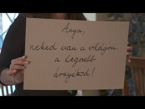 Anya, Neked van a legszebb árnyákod címő feliratot tart valaki a kezében, Részlet a Budapest Voices legújabb klipjéből 
