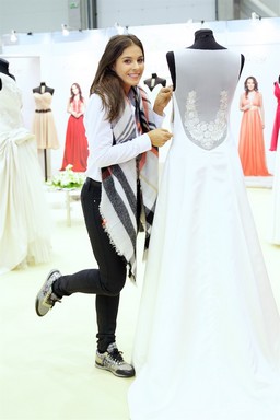 Molnar Andi egy esküvői ruha mellett pózol, Kép: Őszi Esküvő Kiállítás