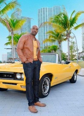 Rosewood, a sorozat főszereplője egy sárga sportkocsi előtt zsebre dugott kézzel, Kép CoolTV