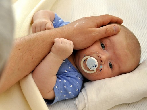 Cumizó kisbabát simogató kéz, Kép: pixaby  