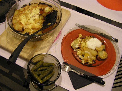 Rakott krumpli tálalva színes, modern asztalon uborkával, Kép: László Márta