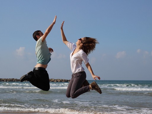 Tengerparton felugrik egy férfi és egy nő, valószínűleg tapsolni fognak a levegőben, Kép: pixabay