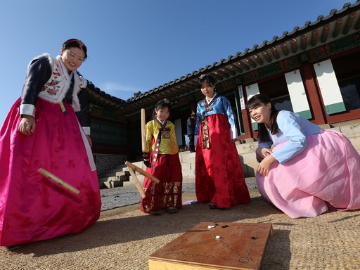 Népviseletbe öltözött lányok tradicionális újévi játékot játszanak, Kép: wikimedia   