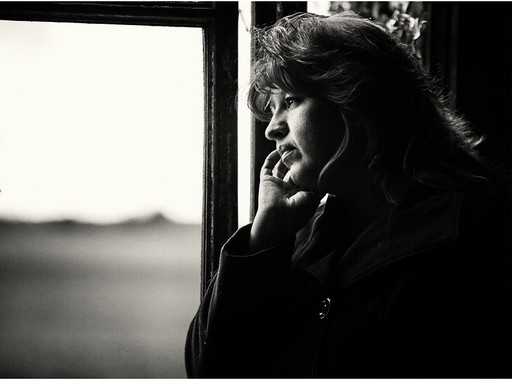 Ablakon kinéző bánatos nő, fekete-fehér kép,Fotó: pixabay