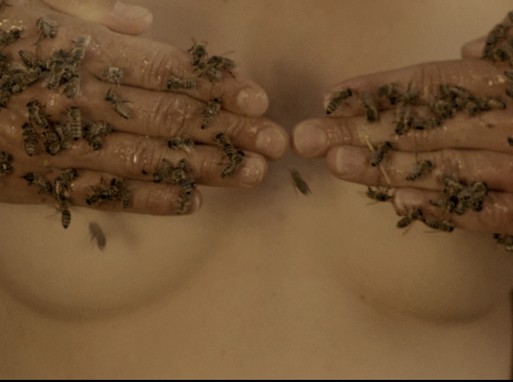 Két mézes kéz tele méhhel eltakar két női mellett, Kép: filmkocka