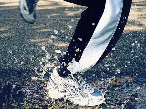 Futó sportoló lábáról közeli felvételi, amikor épp egy pocsolyába csobban, Kép: pixabay 