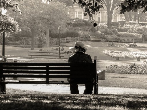 Nő egyedül ül egy köztéri padon, Kép: 