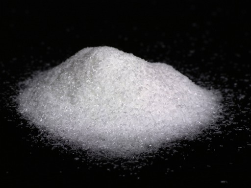 Fekete alapon fehér kristályos anyag, ez a nátrium glutamát, Kép: wikimedia