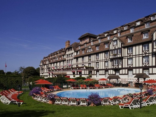 Alpesi jellegű szálloda, előtte medence, napágyak
